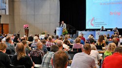 Bischof Werner Philipp spricht am Rednerpult zur Süddeutschen Jährlichen Konferenz 2026 in Gerlingen. Vor ihm sitzen die Delegierten im Plenum. Auf der Leinwand sind Konferenzmotto und ein Logo der Evangelisch-methodistischen Kirche zu sehen.