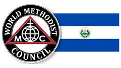 Logo des Weltrats methodistischer Kirchenneben der blau-weißen Flagge El Salvadors mit Staatswappen.