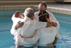 Viel Wasser zum Taufen. Pastor Walther Seiler von der EmK-Gemeinde Albstadt tauft Migranten im Hallenbad.