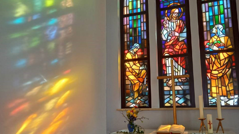 Das farbenfrohe Fensterbild in der evangelisch-methodistischen Friedenskirche in Zwickau zeigt Jesus zwischen der hörenden Maria und der agierenden Marta.