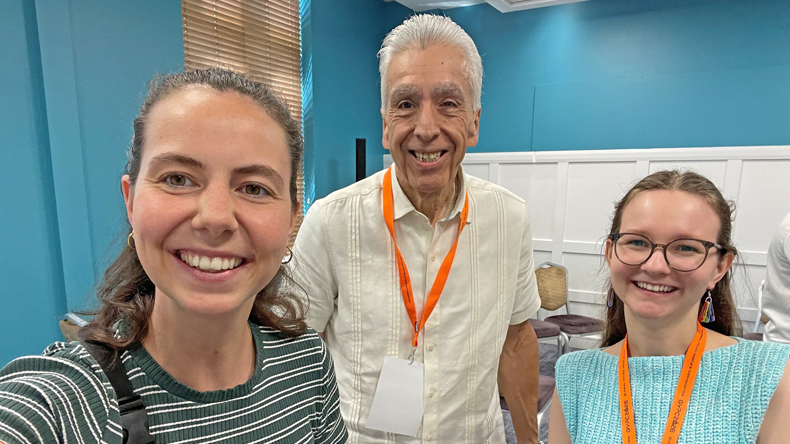 Bei der GYPC in Dublin: Lea Schmidt, Bischof Ruben Saenz Jr. und Imke Sewing (von links). Lea Schmidt (links, gestreiftes Shirt), Bischof Ruben Saenz Jr. (Mitte, weißes Hemd) und Imke Sewing (rechts, hellblaues Oberteil) stehen bei der Global Young People’s Convocation in Dublin zusammen. Alle drei lächeln in die Kamera.